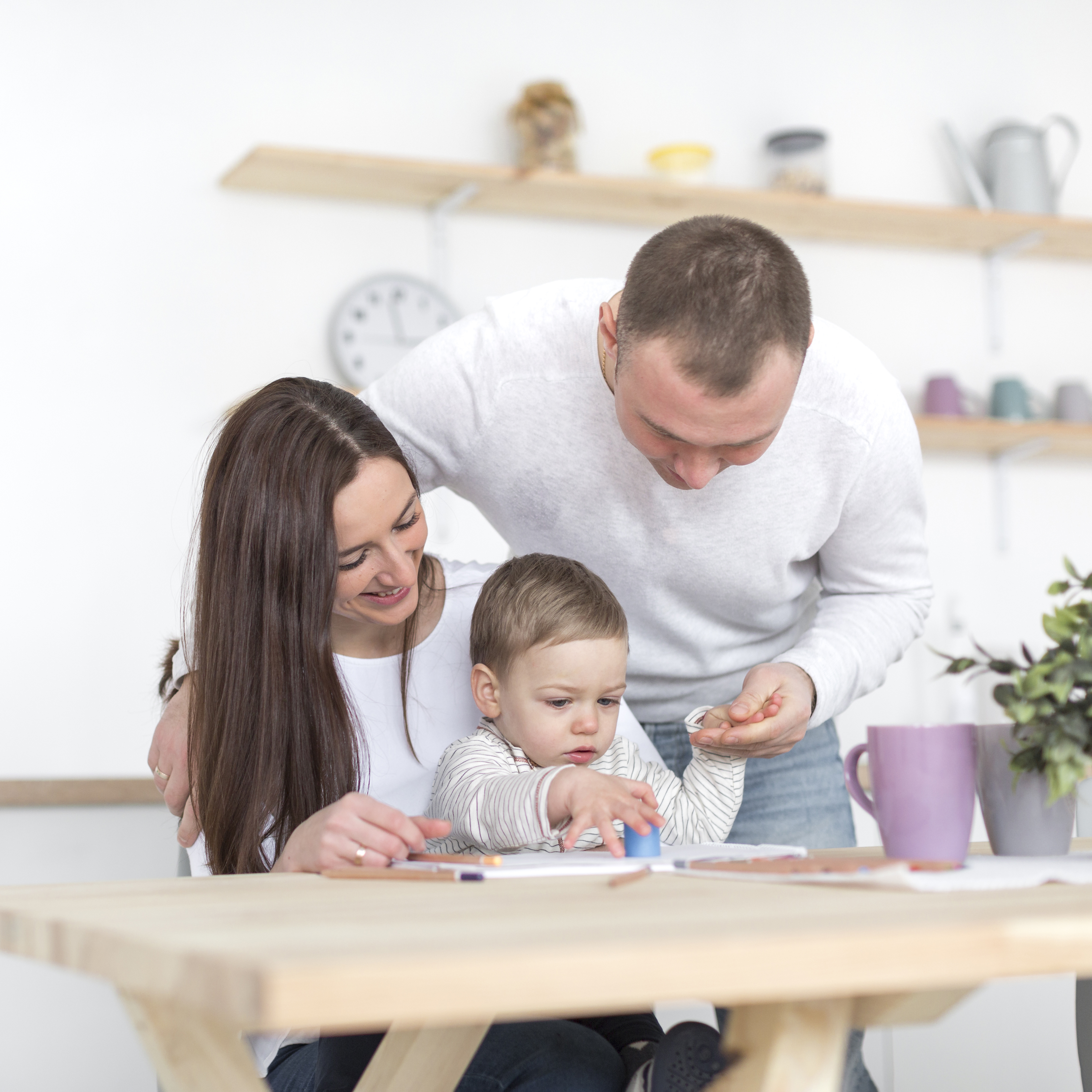 front-view-happy-parents-with-baby-kitchen